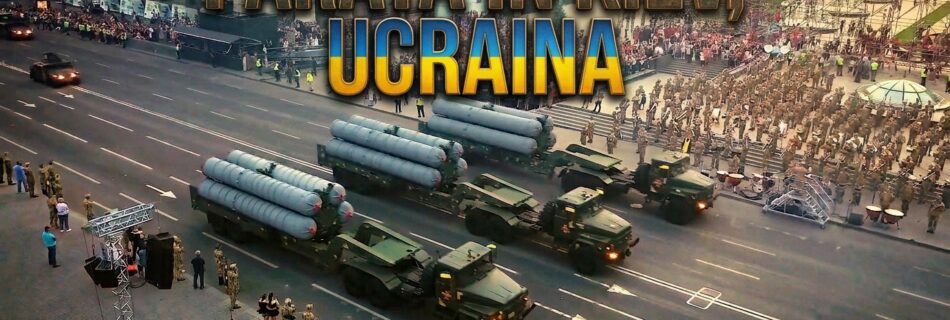 Una veduta aerea di una parata militare che si svolge su Via Khreshchatyk a Kiev, in Ucraina. La strada è percorsa da tre enormi camion trasportatori che esibiscono fieri un totale di nove missili a lungo raggio. Al di là del corteo, si distinguono chiaramente edifici storici monumentali e una folla di spettatori che assiste all'evento. Un testo sovrapposto in grande carattere e in alto recita: "PARATA IN KIEV, UCRAINA". In basso a sinistra, una bandiera ucraina affianca la dicitura "KIEV, KHRESHCHATYK". In basso a destra, sono indicati i crediti: "UN DOCUMENTARIO ESCLUSIVO DI APOSTROPHE / FOTOGRAFIA DI OLEKSANDR HONCHAROV